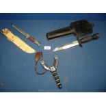 A sling and two knives, one being a divers knife and a sheath knife.
