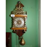 A Wall Clock having Atlas pediment, chiming movement and pear shaped brass weights,