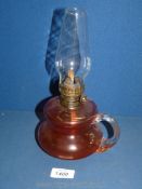 A small cranberry glass paraffin light with handle.
