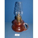 A small cranberry glass paraffin light with handle.