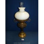 A brass oil lamp with white shade