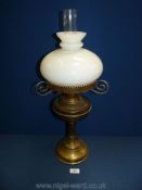 A brass oil lamp with white shade