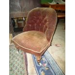 A late Victorian buttoned back Nursing Chair having turned front legs and upholstered in brown