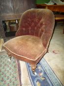 A late Victorian buttoned back Nursing Chair having turned front legs and upholstered in brown