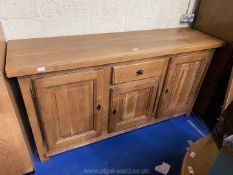 A good mid Oak Sideboard having three cupboards with raised and fielded panelled doors and a drawer