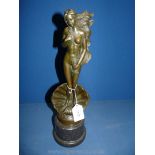 A bronze figure of a nude woman with long hair.