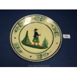 An HB Quimper plate depicting a Breton man in landscape holding a pipe, 9 1/2'' diameter,