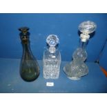 A trio of glass decanters comprising of a square crystal decanter 10 1/4" high;