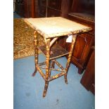 A cane conservatory Table having woven top, lacquered shelf and cross stretcher below,