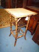 A cane conservatory Table having woven top, lacquered shelf and cross stretcher below,