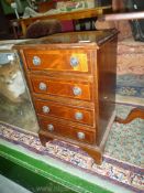 A compact reproduction Mahogany lightwood strung and crossbanded Chest of four short drawers,