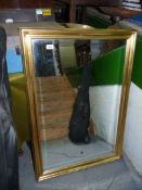 A large bevelled glass mirror in a gilt frame. 28 1/4" x 40 1/4".