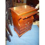 A cross-banded Yew wood finished cabinet with pull-out green leather surfaced slide,