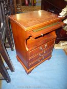 A cross-banded Yew wood finished cabinet with pull-out green leather surfaced slide,