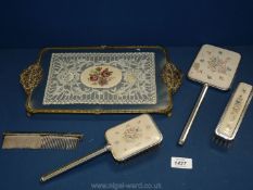 A glass dressing table tray with lace under the glass on spade feet and with embroidered brush,