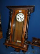 An Edwardian wall clock with ebonised pillars and a presentation plaque dated 1924,