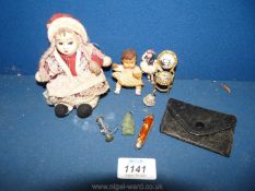 Two small dolls, a small leather purse, tiny bell,