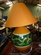 A medium orange and green Louis Drimmer table lamp and matching shade.