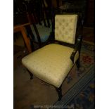 A circa 1900 ebonised framed, gold highlighted Nursing Chair having turned front legs,