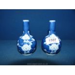 A pair of 19th Century Chinese small bottle vases, painted in blue with prunus decoration.