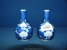 A pair of 19th Century Chinese small bottle vases, painted in blue with prunus decoration.