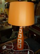 A tall, slim modern design Louis Drimmer orange table lamp and matching shade.