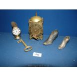 A small brass key, brass clock with key, temperature gauge and two small plated shoes.