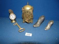 A small brass key, brass clock with key, temperature gauge and two small plated shoes.