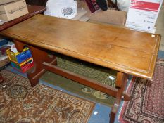 A mid Oak hall Centre Table standing on shaped slab legs united by a pegged central stretcher,