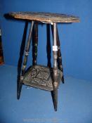 A small hand carved ebonised two tier table,