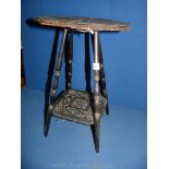 A small hand carved ebonised two tier table,