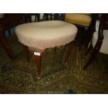 A kidney shaped Stool having beige over-stuffed seat and standing on dark cabriole legs