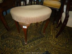 A kidney shaped Stool having beige over-stuffed seat and standing on dark cabriole legs