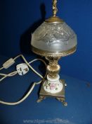 A small ceramic table lamp with metal base and frosted glass shade with cherub finial,