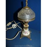 A small ceramic table lamp with metal base and frosted glass shade with cherub finial,