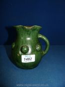 A Ewenny Pottery jug with side handle and raised domes around the body,