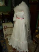 A Wedding Dress with three quarter puff sleeves, pink bows and roses, size 10/12, with veil.