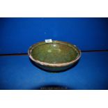 A speckled green glazed bowl by Ewenny Pottery; 1902, chips and wear to rim, 9 1/2" diameter,