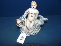 A very rare French Nevers faience figure of the Cherub on a dolphin c.