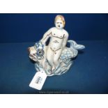 A very rare French Nevers faience figure of the Cherub on a dolphin c.