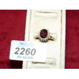 A 9 ct garnet and diamond ring hallmarked size 'R 1/2'.