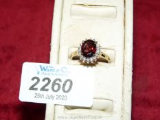 A 9 ct garnet and diamond ring hallmarked size 'R 1/2'.