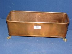 A copper and brass trough with lion handles and spade feet.