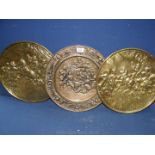 Three brass wall plaques.