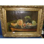 A large heavy gilt framed oil on canvas of a still life of fruit on a table, initialled lower right,