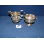 A small Indian white metal embossed jug and bowl
