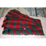 Chequered fringed picnic rug with patch repair.