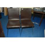 Two faux leather dining chairs.