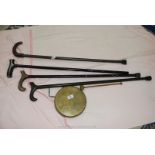 Four various walking sticks and brass dinner gong.