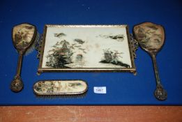 An oriental print tray with mirror and two brushes.